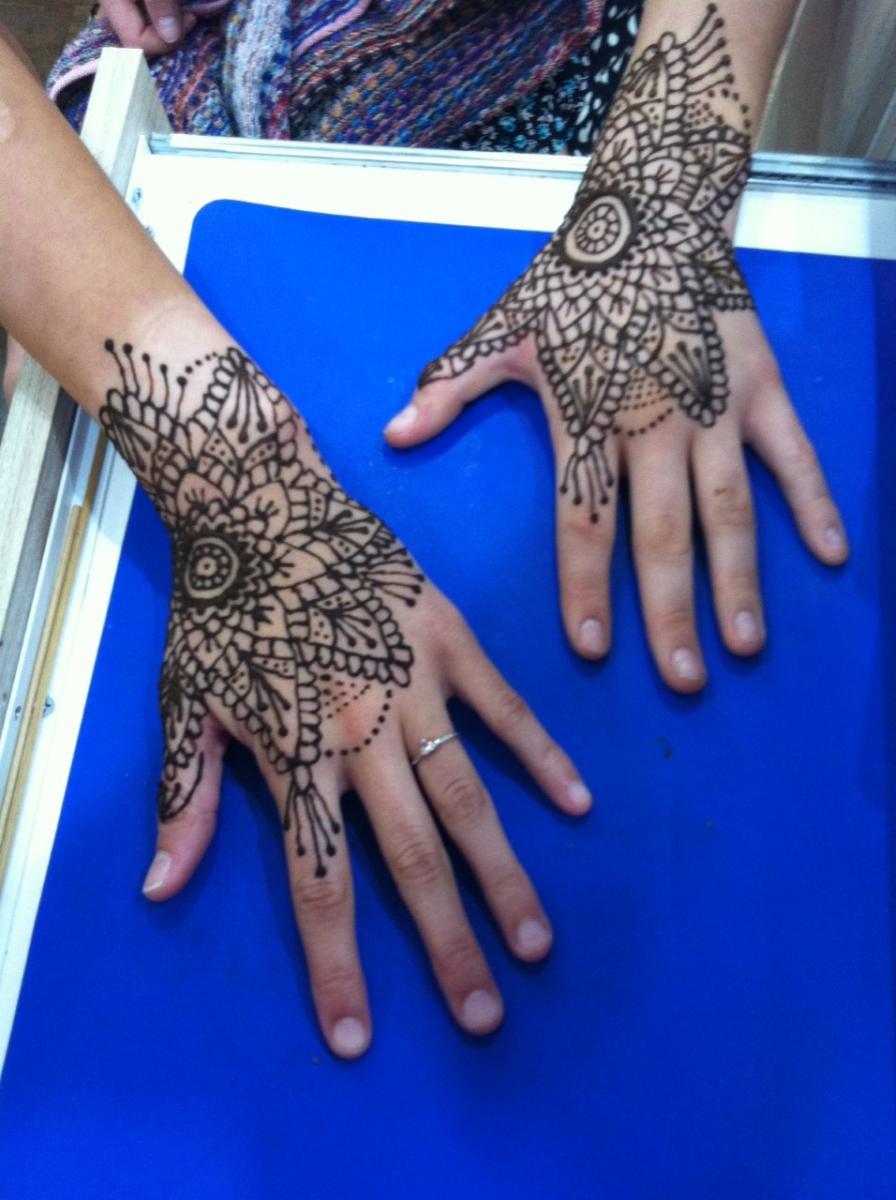 Free Photo | Master tattooing mehndi on lady hand